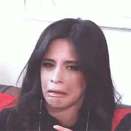 a woman with long black hair is making a funny face with her mouth open .