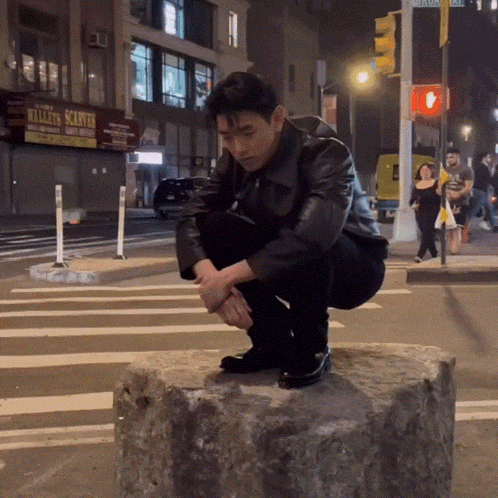 a man squatting on a rock in front of a sign that says willett 's scratter