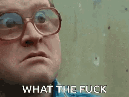 a man wearing glasses is making a face and says what the fuck .