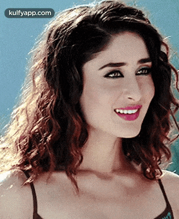 a close up of a woman with curly hair smiling