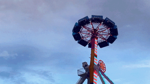 a colorful ferris wheel is against a cloudy sky