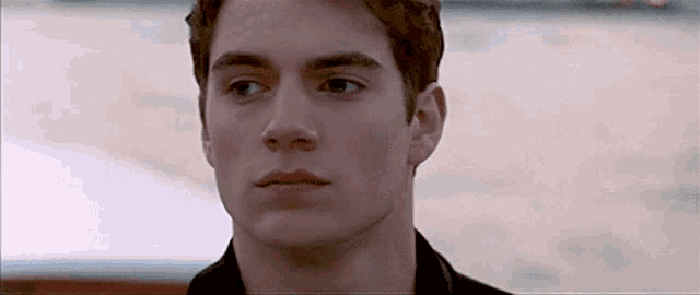 a close up of a young man 's face with his eyes closed .