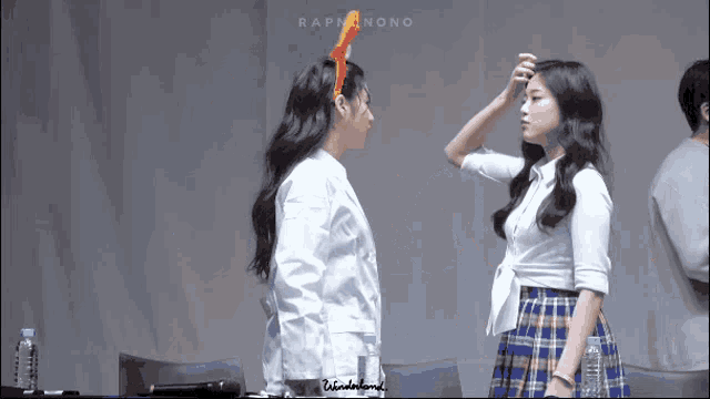 two girls are standing next to each other and one has a red headband on