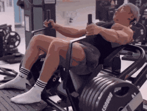 a man is doing squats on a machine that says ' goalst ' on it