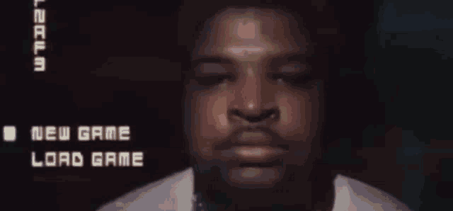 a close up of a man 's face with the words new game and load game on the screen