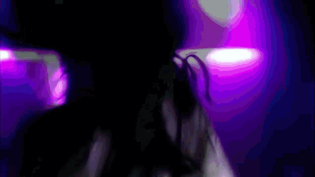 a blurry picture of a woman 's face with purple lights in the background