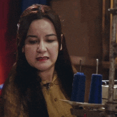 a woman sitting in front of a sewing machine with blue spools on it