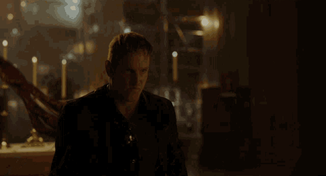 a close up of a bloody monster in a dark room with lights behind him