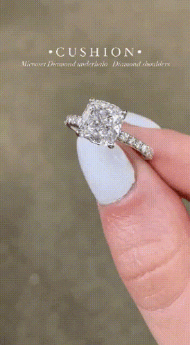 a woman with white nails is holding a diamond ring on her finger .