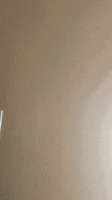 a close up of a wall with a white light switch on it