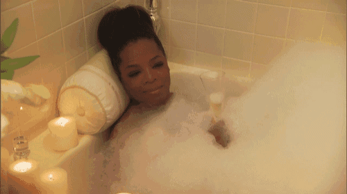 a woman in a bathtub with a glass of wine