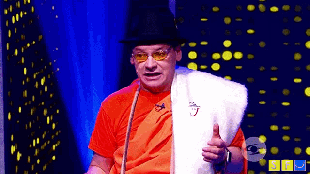 a man in an orange shirt and a black hat is holding a white fur coat