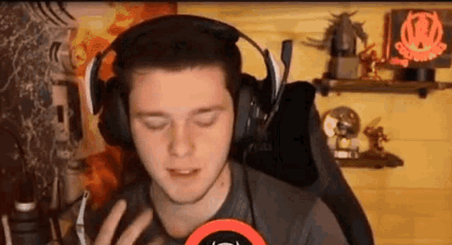 a man wearing headphones is sitting in a chair in front of a microphone in a room .