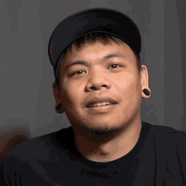 a man with a black hat and black ear plugs