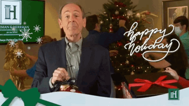 a man in a suit is standing in front of a christmas tree with the words happy holiday written on it