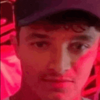 a man wearing a hat is making a funny face in front of a red background .