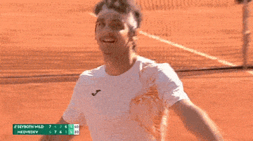 a man on a tennis court with a scoreboard that says seyroth wild