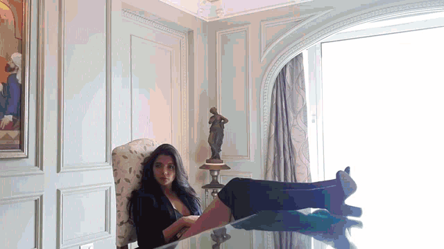 a woman is sitting in a chair with her legs crossed