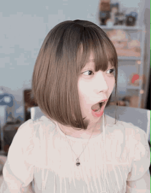a girl with a surprised look on her face wearing a necklace
