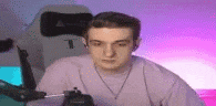 a man is sitting in a chair wearing headphones and a purple shirt .