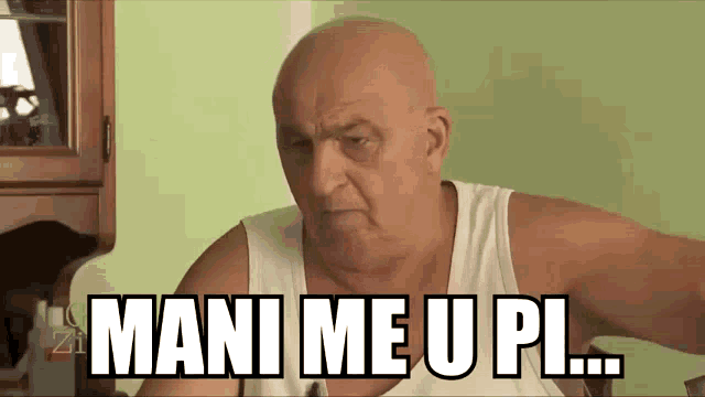 a bald man in a white tank top says mani me u pl