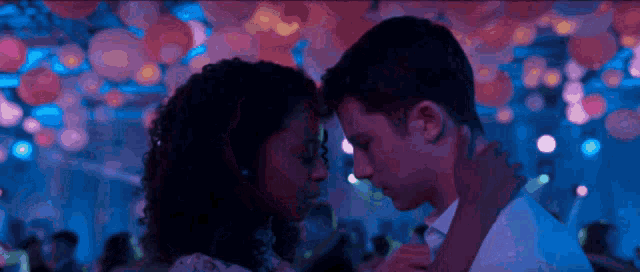a man and a woman are dancing in a dark room