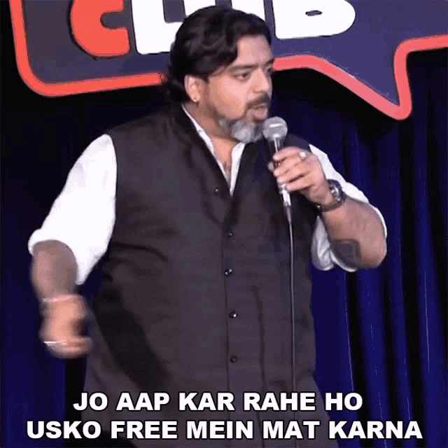 a man stands in front of a microphone with the words jo aap kar rahe ho usko free mein mat karna below him