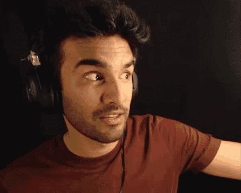 a man wearing headphones and a red shirt looks to the side