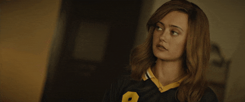 a woman wearing a black and yellow jersey with the number 8 on it