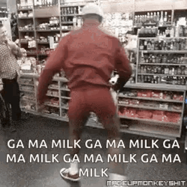 a man in a red jacket and shorts is standing in a store .