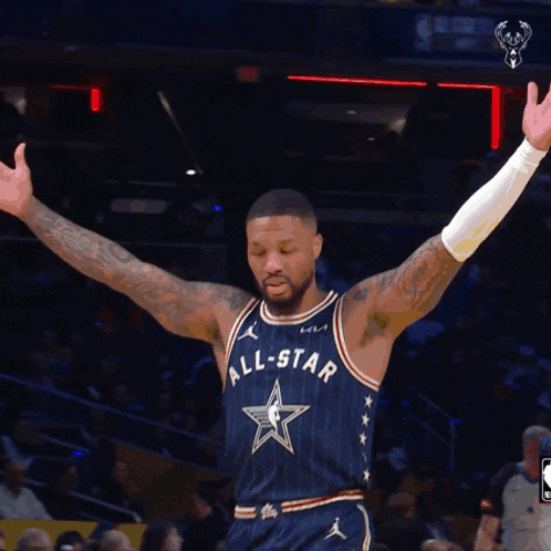 a basketball player wearing an all star uniform stands on the court with his arms outstretched