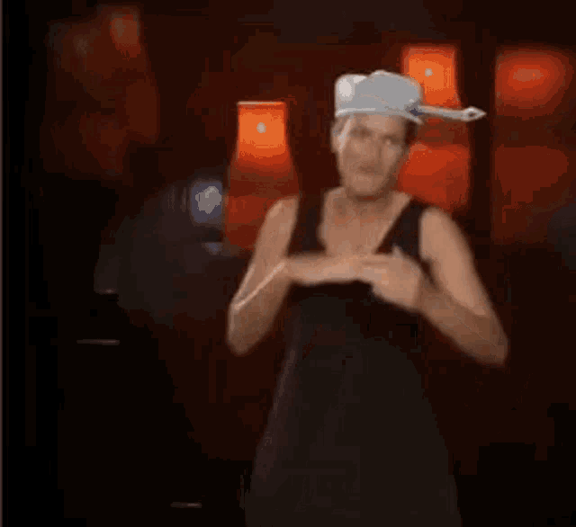 a woman in a black dress and a cowboy hat is dancing in front of red lamps .