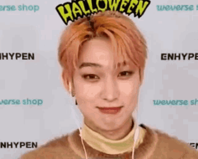 a young man wearing a halloween headband and headphones is smiling .
