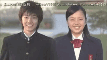 a boy and a girl are standing next to each other smiling for the camera