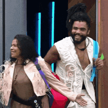 a man and a woman are standing next to each other smiling