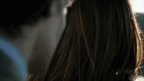 a close up of a woman 's face with a man behind her