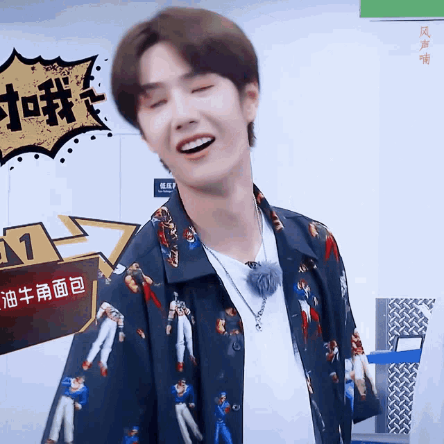 a man wearing a shirt with chinese characters on it smiles