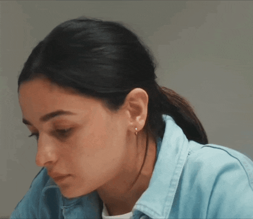 a close up of a woman 's face wearing a denim jacket