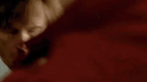 a close up of a person 's face with a red background .