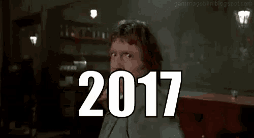 a man is sitting in front of a sign that says 2017 on it .