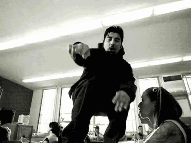 a man with a beard is dancing in a room with a woman .