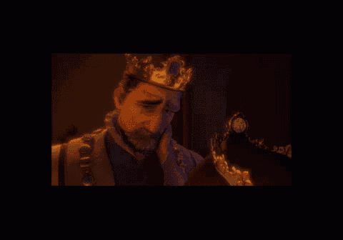 a man with a crown on his head is looking at a woman with a crown on her head