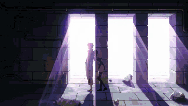 a couple standing in a dark room with a light coming through the windows
