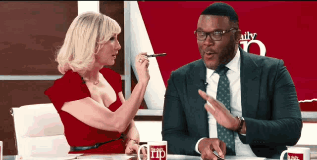 a man in a suit and tie is talking to a woman on a daily grip show