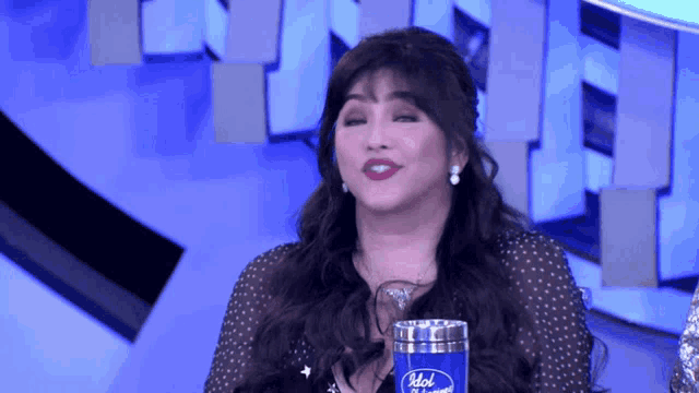 a woman holding a cup that says idol