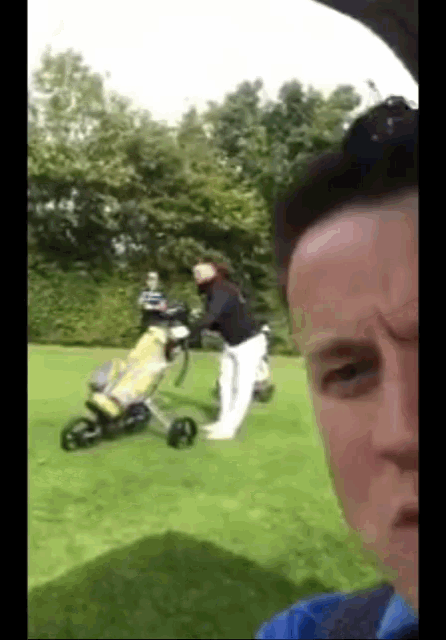a man is taking a picture of a golfer on the golf course