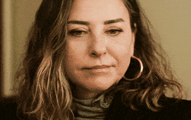 a close up of a woman 's face with a serious look on her face