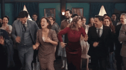 a group of people in suits and dresses are dancing