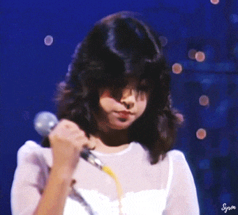 a woman singing into a microphone with the word synon on the bottom
