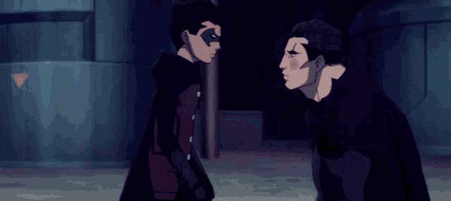a man in a black cape is hugging another man